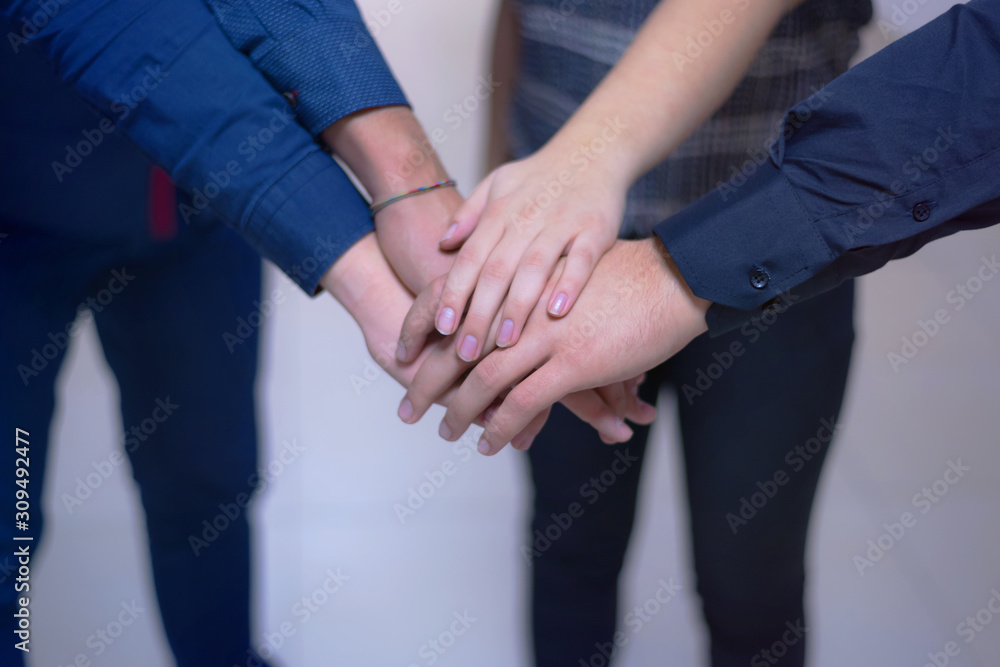 Young business people, Teamwork Stacking Hand Concept. Close up of young people putting their hands together. Business people with stack of hands showing unity and teamwork.