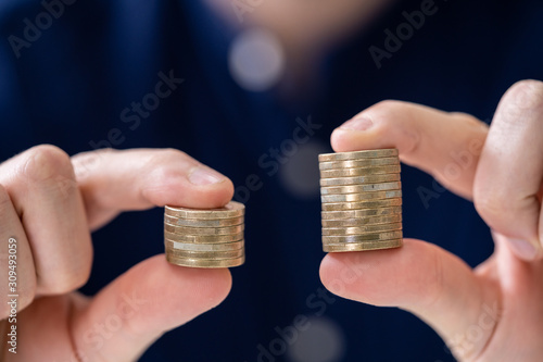 Obraz na płótnie Man Holding Two Coin Stacks