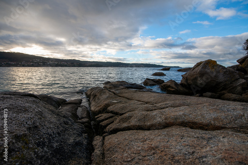 Landscape of a rocky beach with cloudy sky, silk effect, long exposure in Cangas, O Grove, Aldán, Vigo, Pontevedra, Galicia, Spain.