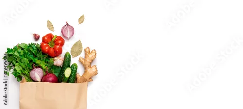 Panel kuchenny z motywem Concept zero waste, ecofriendly, veggie. Flat lay craft paper bag of pepper, cucumbers, ginger, onions, parsley, greens on a white background isolated with copy space. Banner
