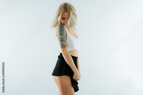 Young blonde sexy woman in mini skirt and crop top exposing booty © Martin Hossa