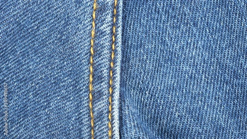 Seam on denim jeans, tracking macro. Denim textile texture. Top view. Slider shot. 4K 422 10 bit photo