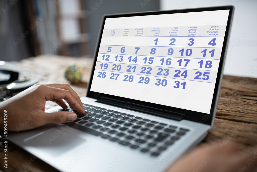 Businessman Looking At Calendar With Daily Agenda Businessman Looking At Calendar With Daily Agenda