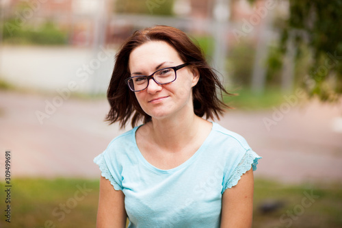Happy young woman in glasses smile outdoors in sunny summer day