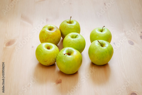 group of green apples on a wooden table