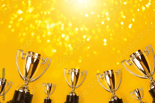 Obraz na płótnie Champion cups on yellow background with sparkling lite