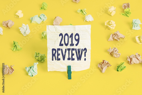 Writing note showing 2019 Review Question. Business concept for remembering past year events main actions or good shows Colored crumpled paper empty reminder white floor clothespin © Artur