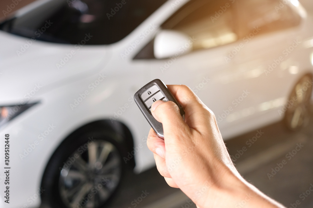 Man hand holding the car remote, he push the remote control to open the car door Man hand holding the car remote, he push the remote control to open the car door