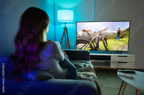 Woman Watching TV While Relaxing On Sofa