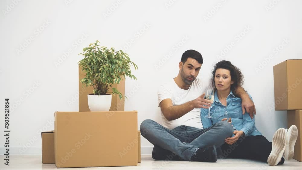 Happy couple are talking while sitting on the floor. Zooming. 4K. Happy couple are talking while sitting on the floor. Zooming. 4K.