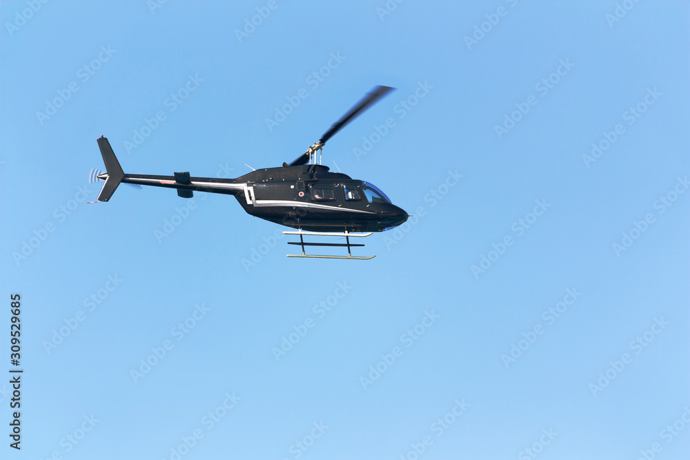 Black passenger helicopter on blue sky background Black passenger helicopter on blue sky background