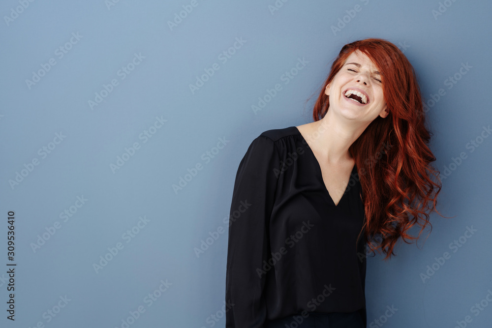 Young woman laughing uproariously at a joke - obrazy, fototapety, plakaty 