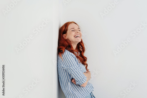 Canvastavla Happy young woman standing chuckling to herself