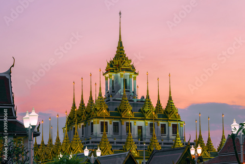 Top of the Loha Prasat chedi of the old Buddhist temple Wat Ratchanatdaram Voravihara against the sunset sky. Bangkok, Thailand
