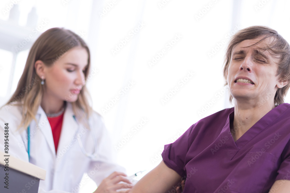 The male patient cried when the female doctor was about to inject the leg to his arm. The male patient cried when the female doctor was about to inject the leg to his arm.