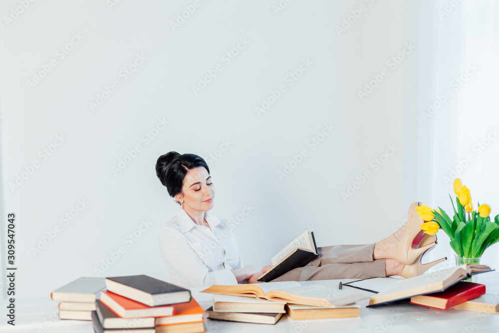 beautiful girl reads books at the table preparing for the exam beautiful girl reads books at the table preparing for the exam