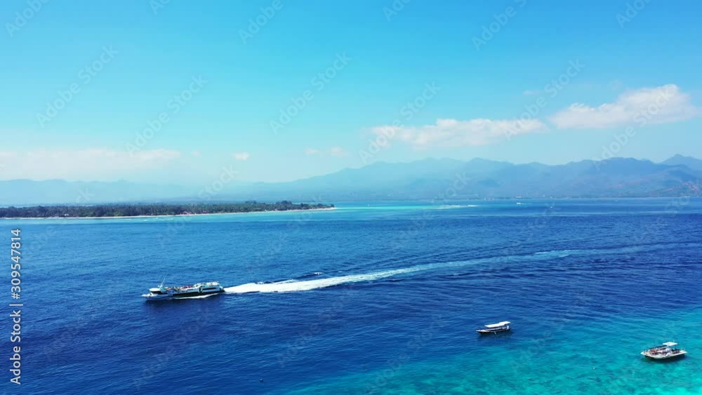 Yacht Sailing To Open Sea Of Caribbean, remote island and mountains covered in the clouds in the background Yacht Sailing To Open Sea Of Caribbean, remote island and mountains covered in the clouds in the background