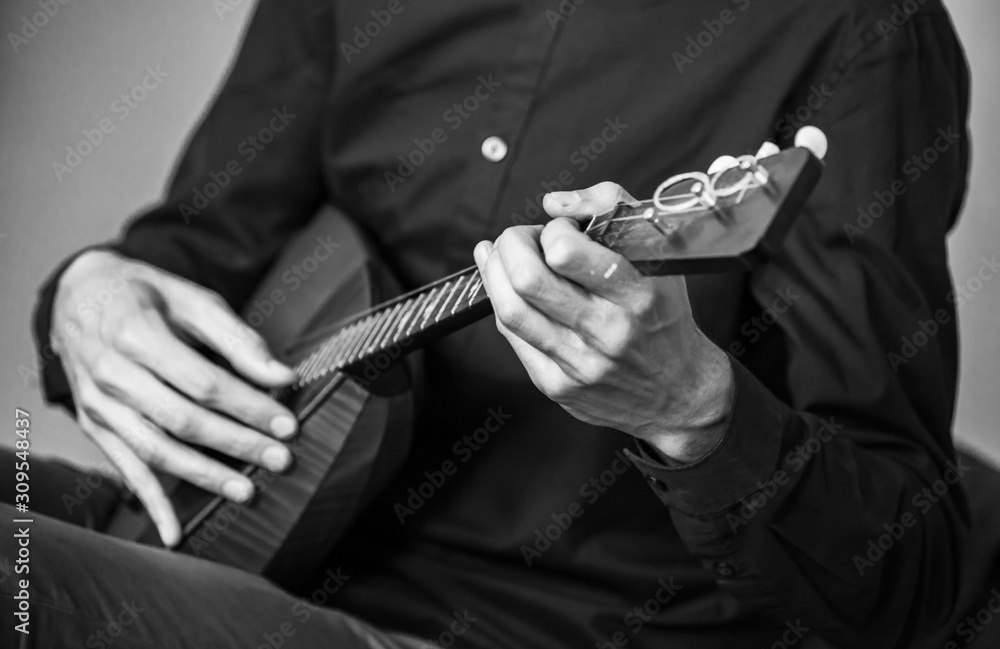 Hands of a man playing balalaika, close-up photo