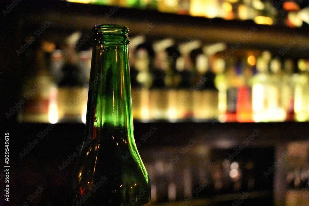 Green beer bottle neck in a bar