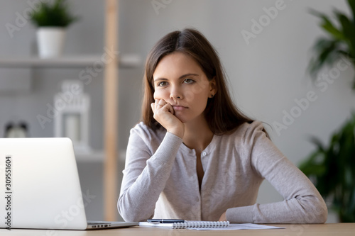Tired young woman feel bored working at laptop photo