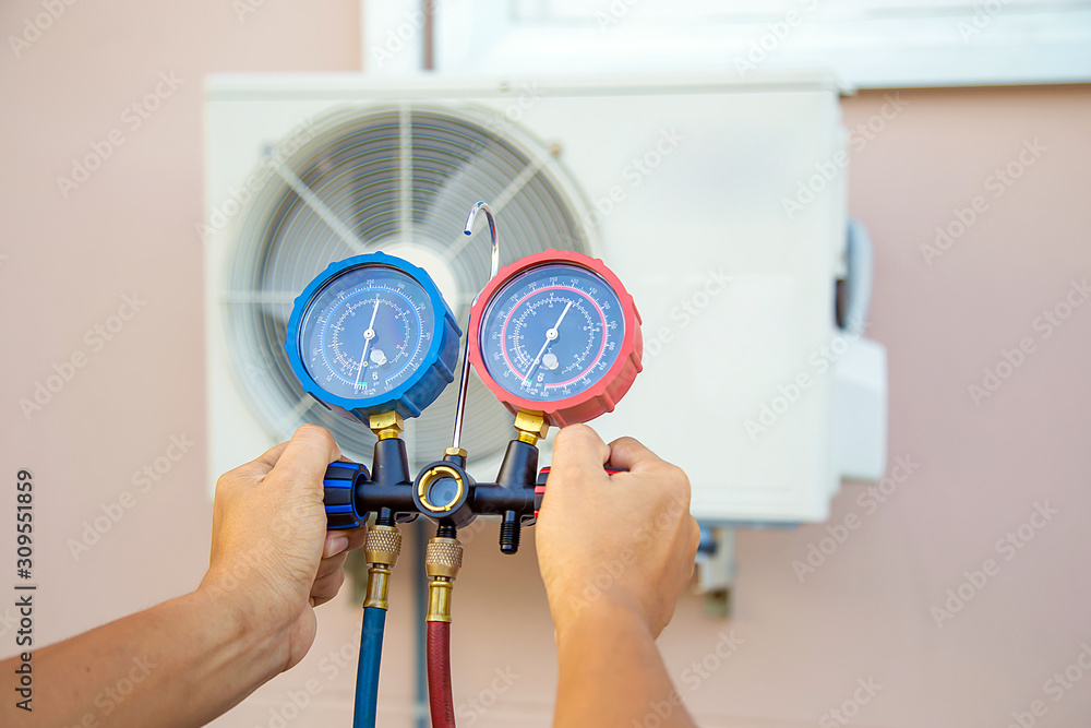 Hands of Technician are using a measuring tool to check Vacuum pump