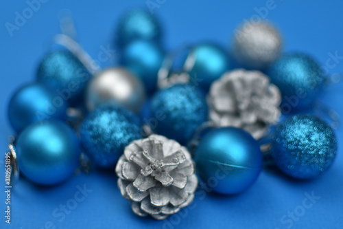 New Year s blue and silver balls and cones on a blue background. Place for an inscription. Card. Christmas. 2020 color. The trend of the year. .Blurred background.