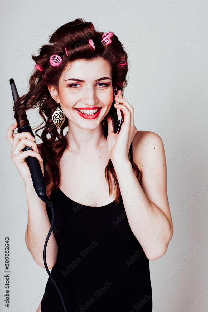 girl with hair curlers talking on the phone and makes the hairstyle girl with hair curlers talking on the phone and makes the hairstyle