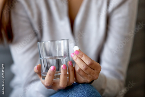Fotografie Close up of hesitant woman doubting to take pill