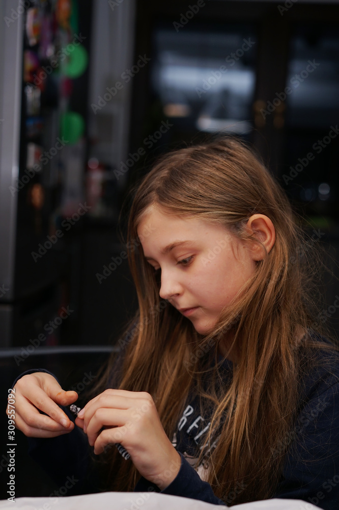 girl while playing - prepares an element of a handmade doll girl while playing - prepares an element of a handmade doll