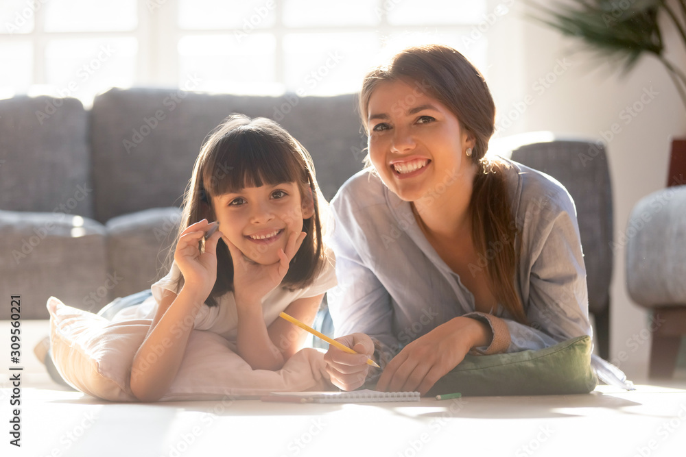 Head shot portrait of smiling mother and daughter playing together