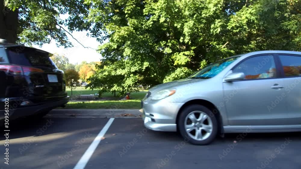 Driving By Vehicles Parked On Parkway With Trees In Background Side View Driving By Vehicles Parked On Parkway With Trees In Background Side View