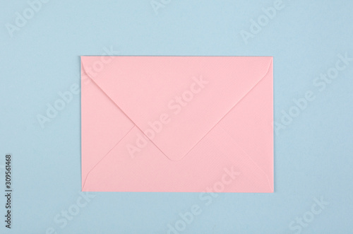 Pink paper envelope composition on blue background.