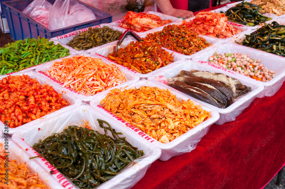 A variety of salads in trays on the counter at the food market in China, street food in the summer