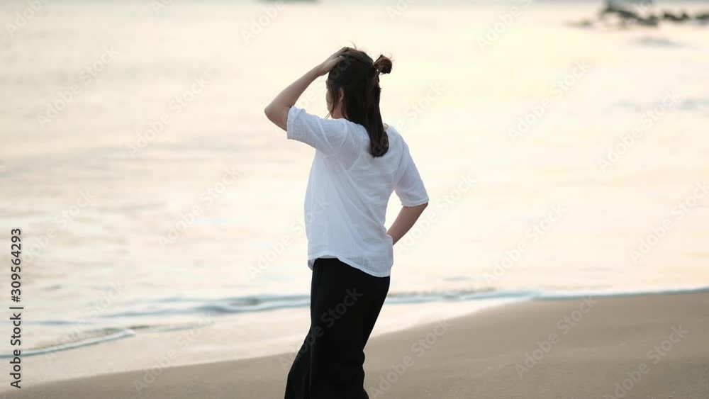 Alone woman walking on tropical beach in sunset light. Alone woman walking on tropical beach in sunset light.