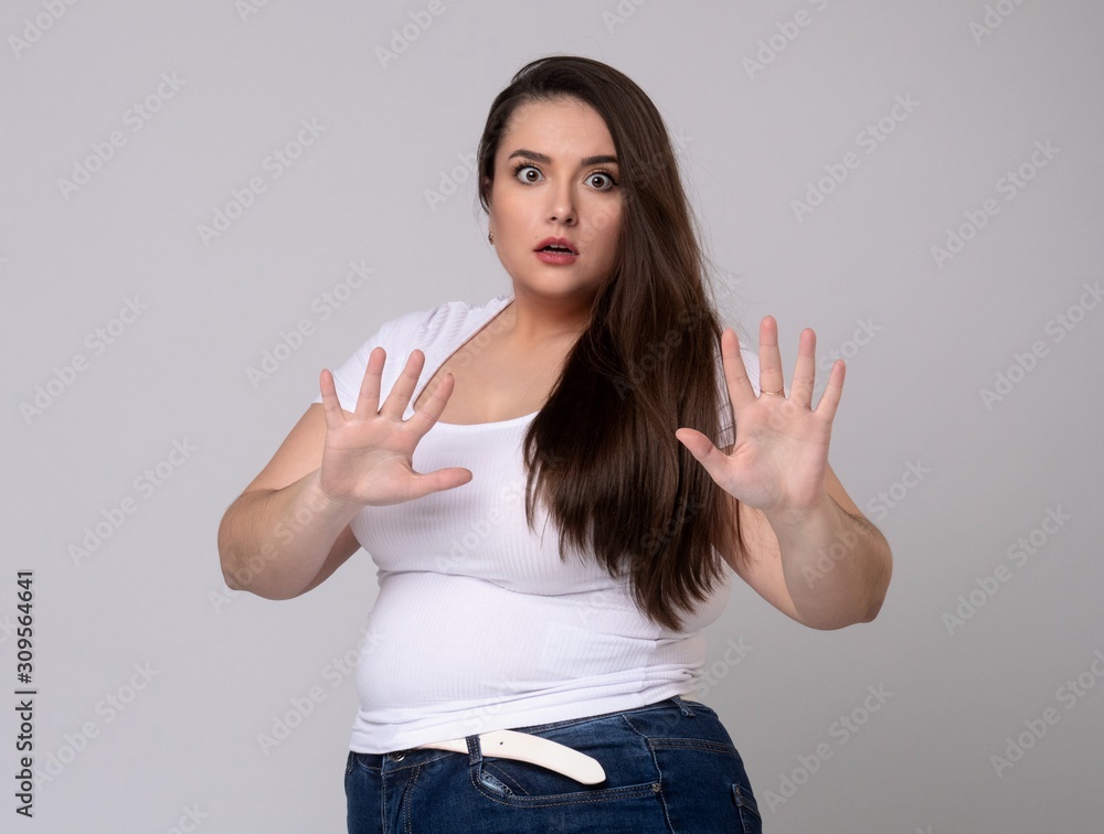 Plus Size Model with long hair gesturing no signal in studio. Plus Size Model with long hair gesturing no signal in studio.