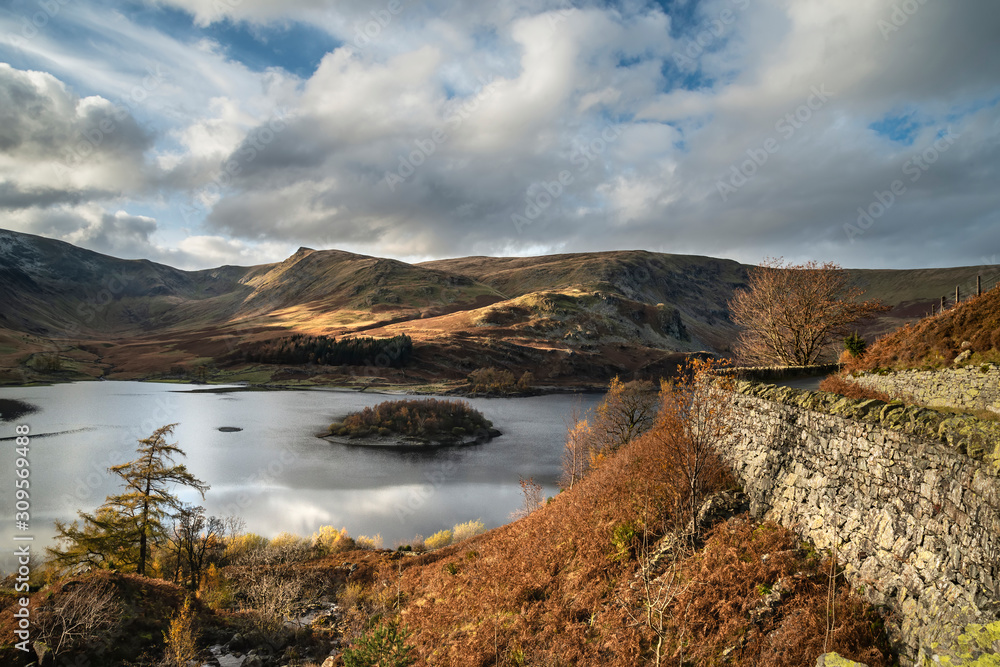 Stunning Autumn Fall landscape of Hawes Water with epic lighting and dramatic sunlight in Lake District Stunning Autumn Fall landscape of Hawes Water with epic lighting and dramatic sunlight in Lake District