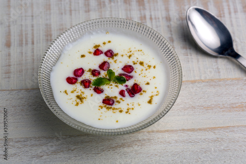 a bowl of curd with  pomegranate sees and chat masala
