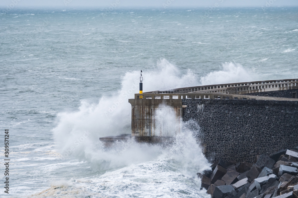 powerful waves breaking at breakwater during a storm