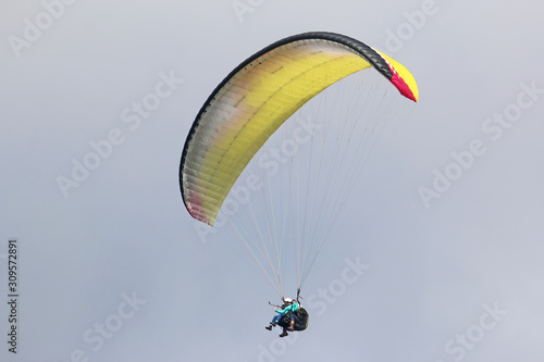 Tandem Paraglider flying wing in a blue sky	