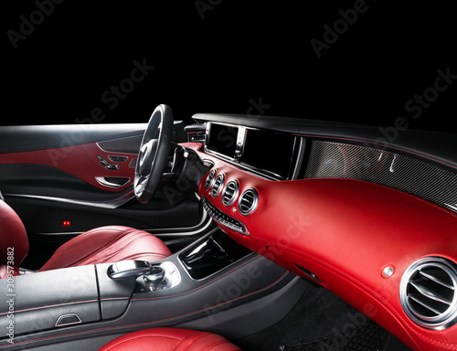 Red luxury modern car Interior with steering wheel, shift lever and dashboard. Clipping path. Detail of modern car interior. Automatic gear stick. Part of leather seats with stitching in expensive car