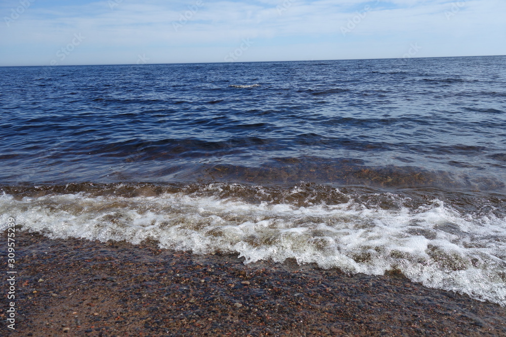 Summer landscape of the lake with clear water, wave, blue sky and horizon. Summer landscape of the lake with clear water, wave, blue sky and horizon.