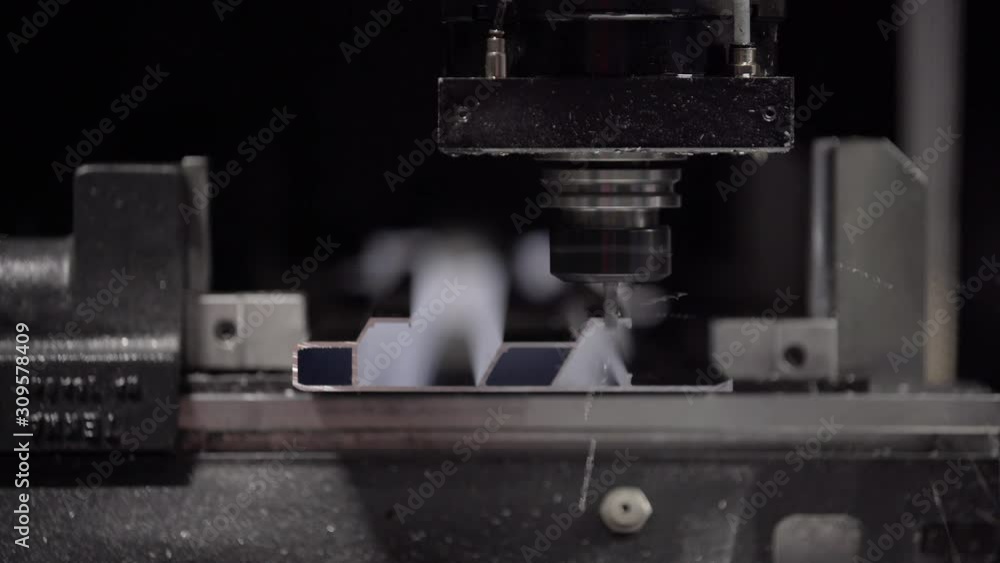 Drilling CNC Machine processes the aluminium profile. Modern tool in heavy industry. New electric tool cut and drill molds. Automatic work for ironwork. Drilling CNC Machine processes the aluminium profile. Modern tool in heavy industry. New electric tool cut and drill molds. Automatic work for ironwork.