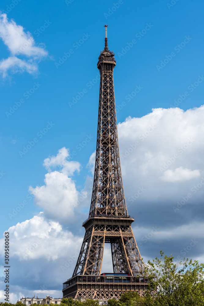 The Eiffel Tower against blue and cloudy sky, a wrought-iron lattice tower on the Champ de Mars in Paris, France, named after the engineer Gustave Eiffel, constructed from 1887 to 1889. The Eiffel Tower against blue and cloudy sky, a wrought-iron lattice tower on the Champ de Mars in Paris, France, named after the engineer Gustave Eiffel, constructed from 1887 to 1889.