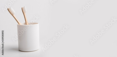 Holder with eco bamboo toothbrushes on white background