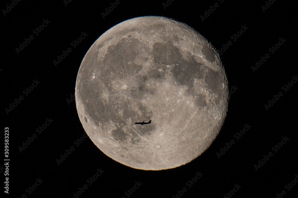 Obraz premium Passenger plane flying in front of full moon at night, Germany