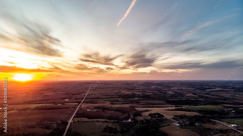 Sunset over a rural countryside with a country road going to the horizon Sunset over a rural countryside with a country road going to the horizon