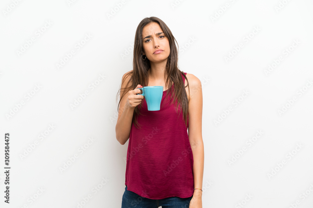 Young woman over isolated white background holding hot cup of coffee Young woman over isolated white background holding hot cup of coffee
