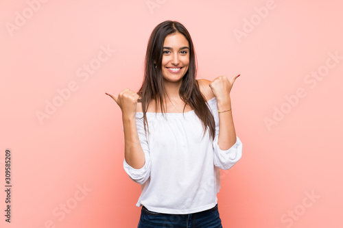 Young woman over isolated pink background with thumbs up gesture and smiling