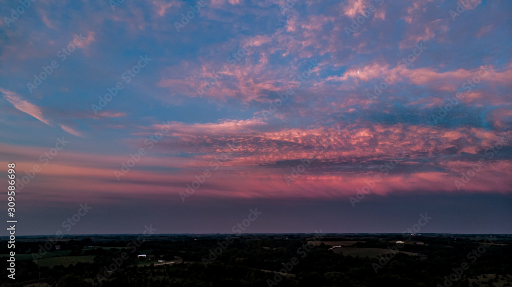 Beautiful sunset and clouds over the rural countryside homes and farms in Nebraska