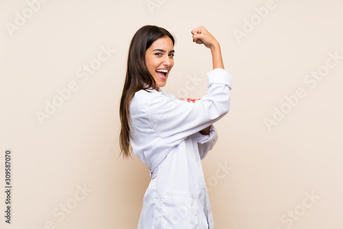 Canvas Print Young doctor woman over isolated background making strong gesture